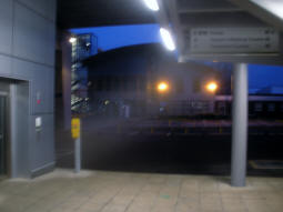 At the bottom of the lift and stairs (right) up to the stop